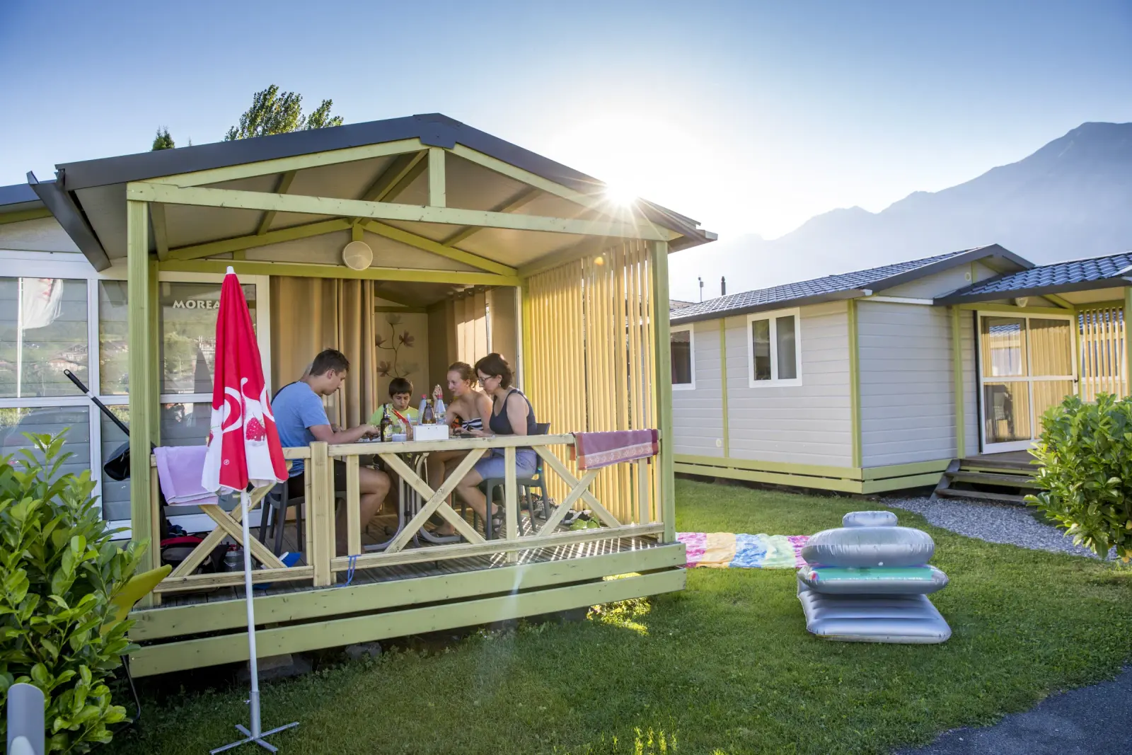Eine Familie auf der Veranda eines Ferienbungalows bei Camping Aaregg