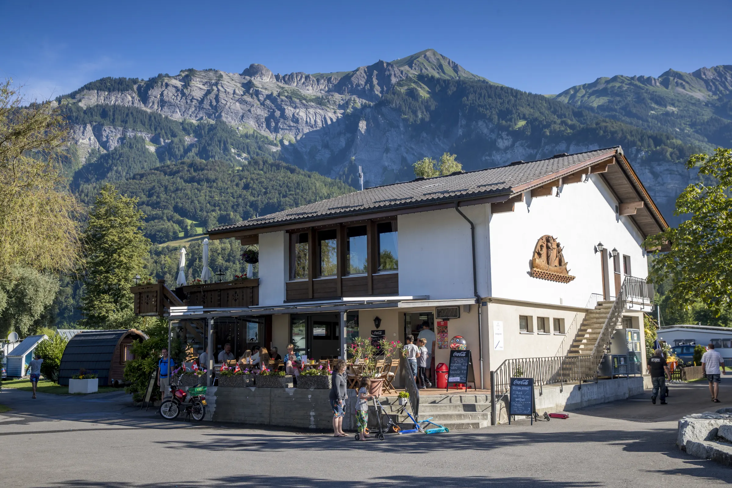 Das Rezeptionsgebäude von Camping Aaregg vor den Bergen
