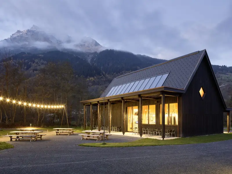 The timber restaurant building at Campadi Trun at dusk, mountains behind